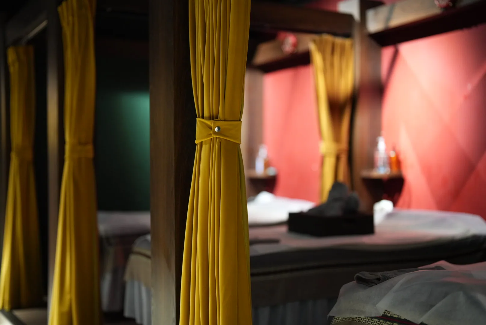 Golden curtains and massage beds at our Yuen Long location; treatment spaces are separated by curtains